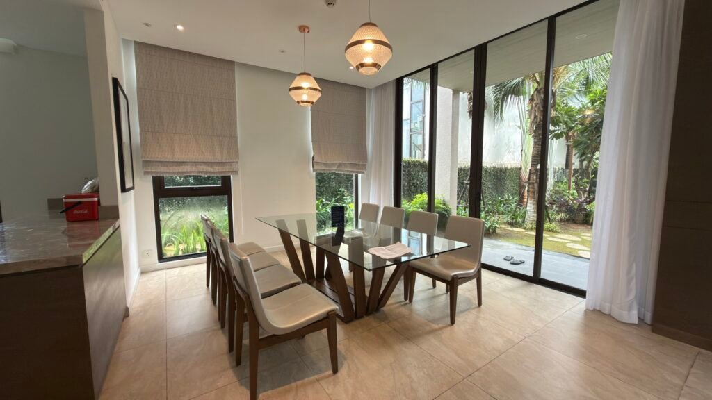 Khu vực bàn ăn và cửa kính nhìn ra vườn trong villa Oakwood Hạ Long